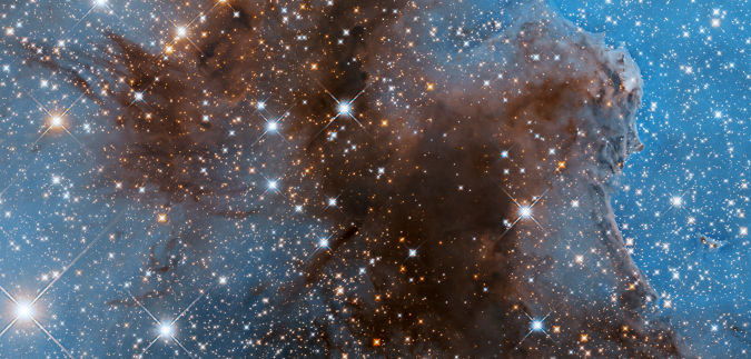 Landscape format; many many stars on a brownish nebula shaped area, light blue background; image by Hubble space telescope Querformat; sehr viele Sterne in einem bräunlich gefärbten Nebelgebilde, hellblauer Hintergrund; Foto: Hubble Weltraumteleskop