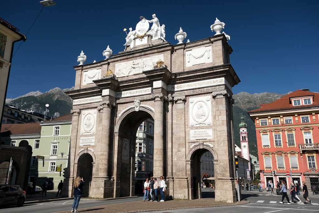 Landscape format; triumphal arch with 3 passages, in the background houses, church tower and mountains